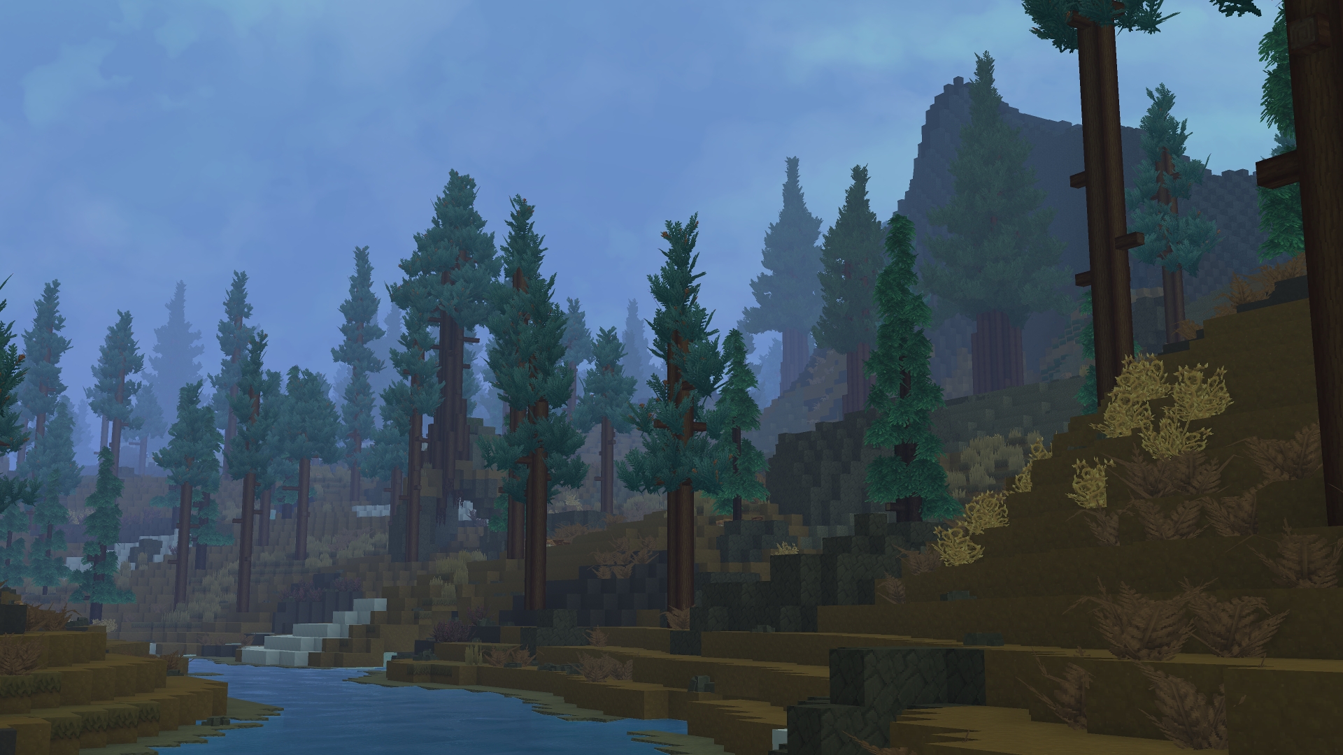 Извилистая река в заснеженной лесной долине с соснами и горами на заднем плане в Зоне 3 (Zone 3)